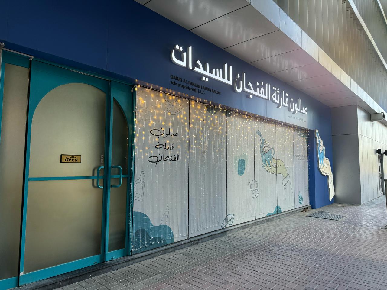 Qareat Al Fenjan ladies salon exterior by day with fairy lights